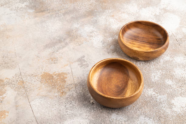 istock Two empty brown wooden bowl on brown concrete. Side view, copy space 1971009073