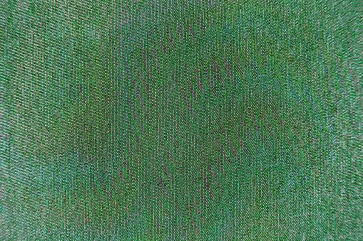 Macro green fabric texture with backlight in the weave