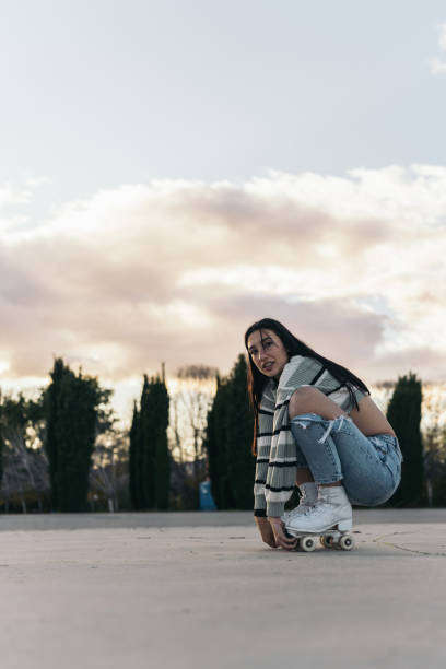istock Relaxed Young Brunette Woman in Quad Roller Skates Taking a Break and Leaning on Boots. Carefree girl in quad roller skates, taking a moment to rest while leaning on her boots. 1971064012