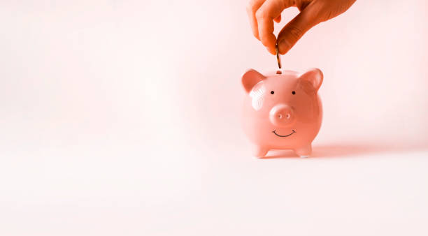 istock Hand puts a coin in a piggy bank. 1971067143