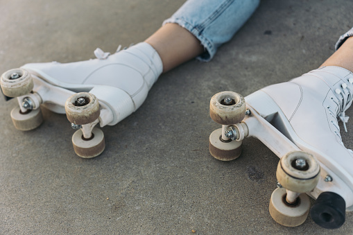 Close-up of a Woman’s Feet Wearing Quad Roller Skates on a Concrete Ground. Captivating shot of a woman’s feet in quad skates