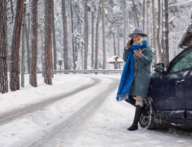 istock Woman with car issues on winter road, phone calling for help 1971084123