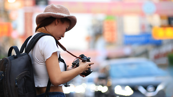 Tourist woman enjoy traveling and taking photos in the city lifestyle of Chinatown street food market in Bangkok, Thailand