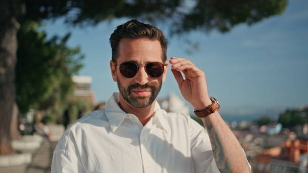 istock Portrait smiling hispanic man taking off sunglasses standing on sunny viewpoint 1971166257