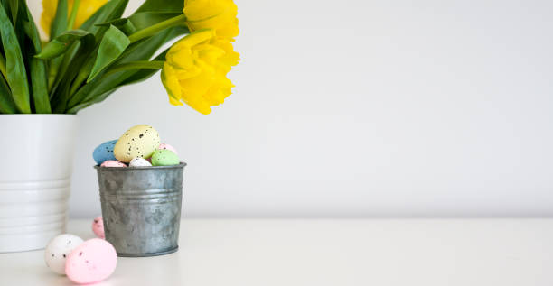 istock Easter eggs in pastel colors and fresh spring yellow tulips on a table. copy space. greeting card with a place to copy the text. 1971181871