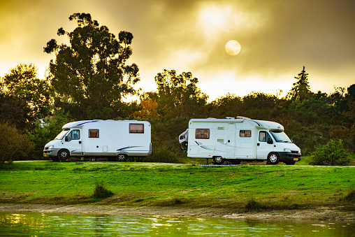 Camping on portuguese nature. Two camper vehicles on lake shore. Travel in wintertime.