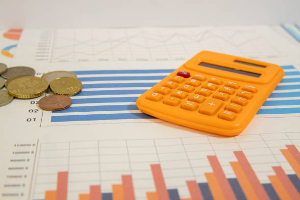 Orange calculator and pen with accounting paperwork for financial tasks
