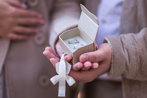 Young couple holding  in hands wedding rings in jewelry box