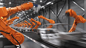 Industrial Robots In Motion At The Automatic Car Manufacturing Factory Assembly Line