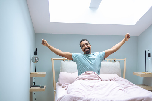 Smiling African American young man waking up and smiling