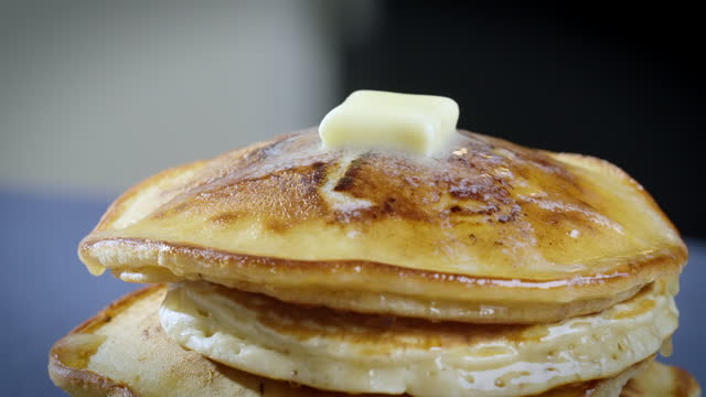 Melting butter on hot thick pancakes. A tower of the thick American pancakes. 4k Slow motion video, 100fps.