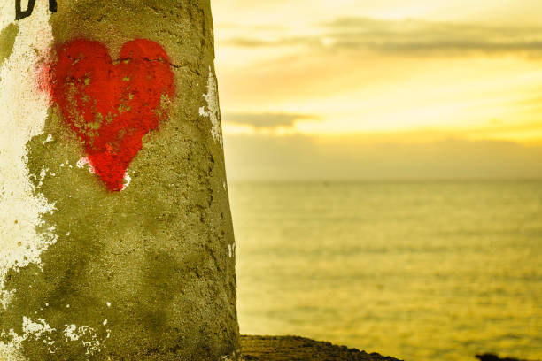 Red heart drawn on beach. Symbol of love