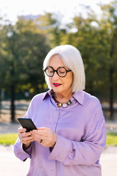 istock senior woman using mobile phone outdoors 1971336411