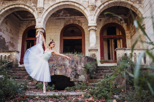 istock Gracious ballerina is performing her dance in abandoned backyard. 1971346631