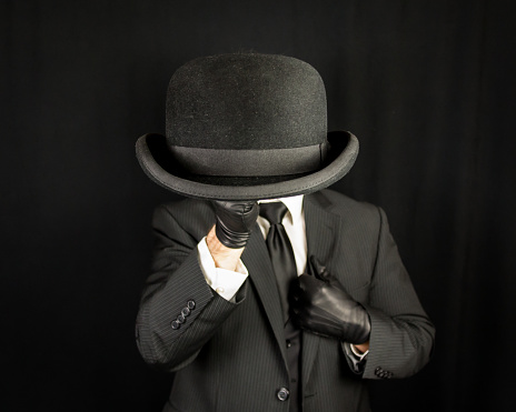 Gentleman in Dark Suit Holding Bowler Hat. Concept of Classic and Eccentric British Gentleman