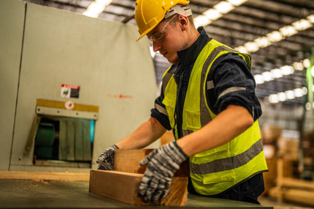 istock Factory engineer man working with timber material. Worker works at heavy machine at industry factory. with machinery equipment plant technology. smart industry worker operating. 1971358466