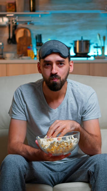 istock Portrait of man with beard holding popcorn bowl 1971390875