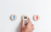 Hand holding circles wooden block with icons men and women for equality between men and women. Gender equality and tolerance.