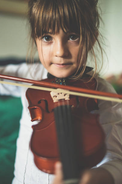 istock Young child, early elementary age girl practices playing the violin 1971400769