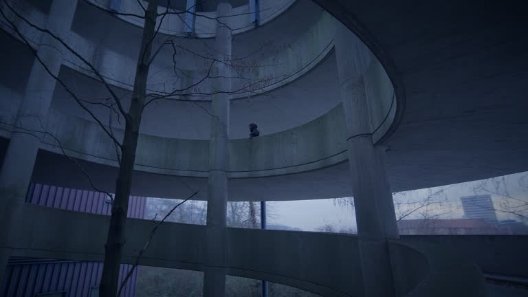 Hooded Fearless Woman Walking in Abandoned Urban Town at Twilight Light