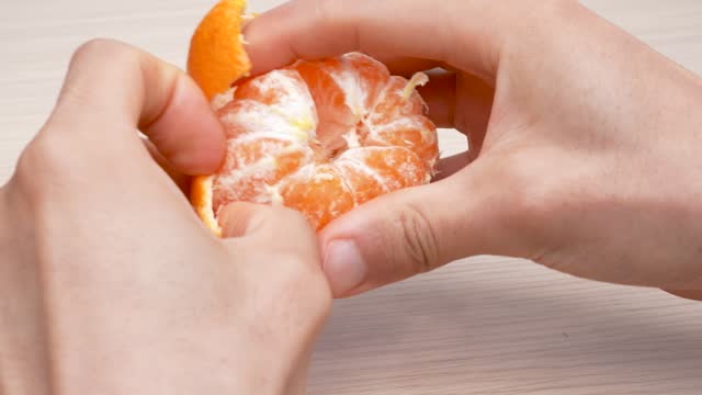 4K video of tangerine peeling on a table.