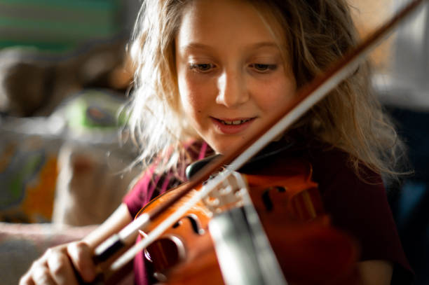 istock Serious elementary age musician, girl child practices playing the violin 1971440183