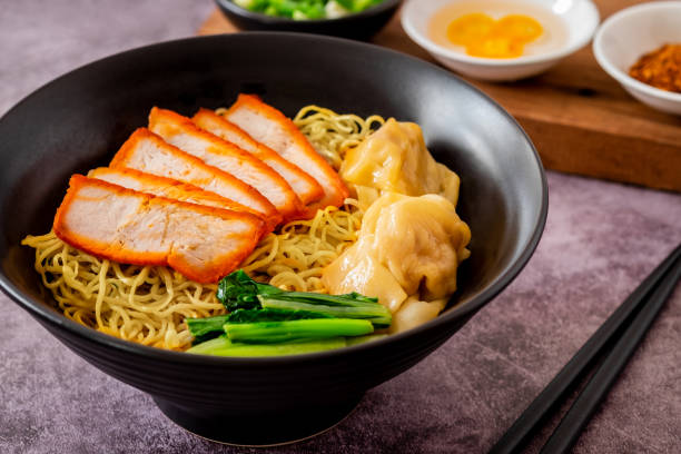 istock Egg noodle with red roasted pork and wonton in black bowl 1971468886
