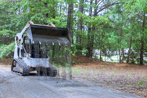 During construction works with bobcat mini loader is moving uploaded bucket crushed stone gravel