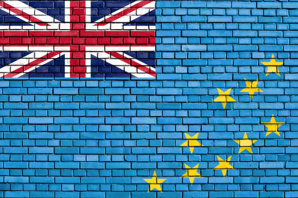 The flag of Tuvalu is shown waving in the wind, featuring a light blue background with the Union Jack in the top left corner and nine yellow stars arranged on the right. The design reflects Tuvalu's connection to the British Commonwealth and its island geography.