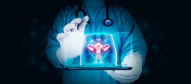 doctor holds a tablet, shows a woman's pelvis x-ray. Uterus. Female reproductive health concept. Development of new technologies to treat cervical cancer. dark background