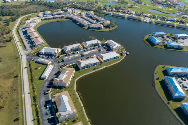 istock Residential condos with leaking roofs covered with protective tarp sheets against rain water leaks until replacement of shingles. Damage of building rooftops as aftermath of hurricane in Florida 1971555946