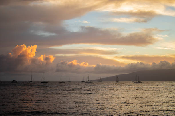 Yacht passing by the Island of Lanai at sunset seen from Maui in Hawaii