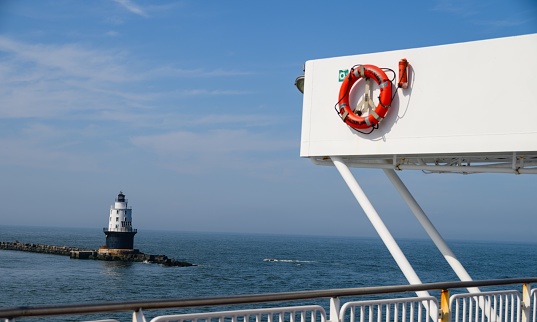 The view of a lighthouse from the deck of a boat.