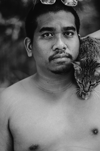 brown man playing with cat