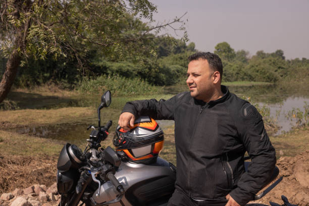 istock Indian biker taking a break looking out at a lake with birds 1971726448