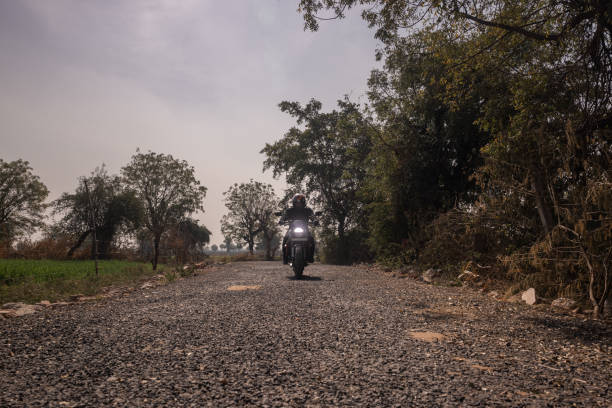 istock Indian biker riding through rural roads, towards the camera 1971726966