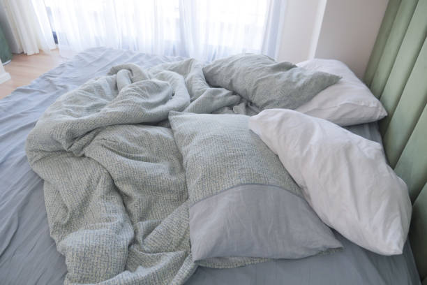 istock messy bed in early morning , messy bed after waking up 1971778068