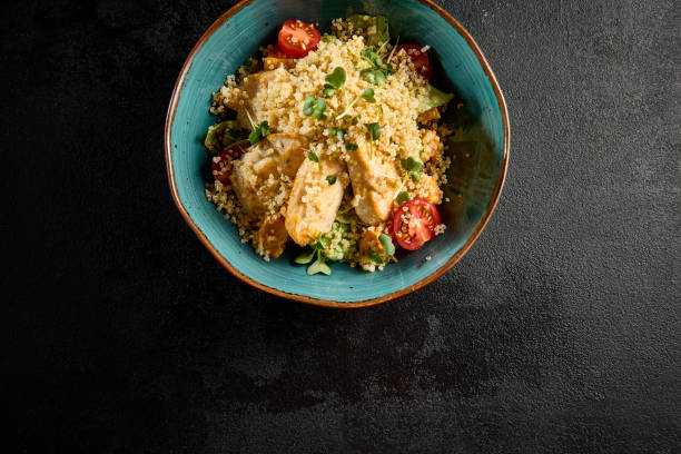 istock Top view of a quinoa salad with grilled chicken, cherry tomatoes, and mixed greens, served in a turquoise ceramic bowl 1971823607