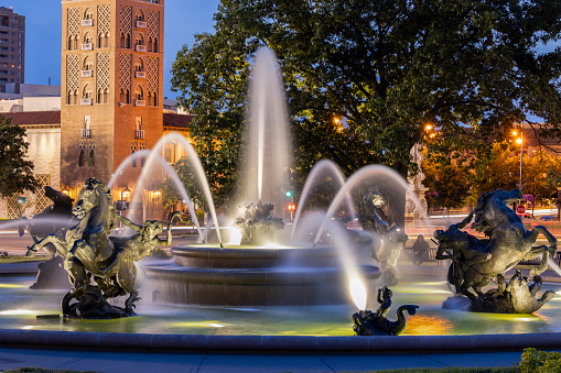 Twilight view of a historic fountain and skyline of Kansas City, Missouri, USA.