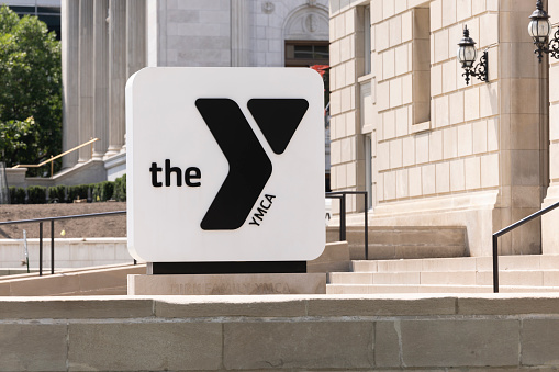 Kansas City, Missouri, USA - June 15, 2023:  Afternoon sunlight shines on the downtown branch sign of the YMCA.