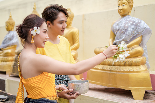 On Songkran Day, young Thai people wear Thai costumes to bathe Buddha statues and play on Songkran Day.