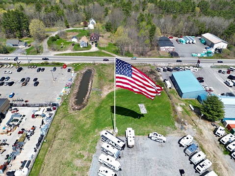 An aerial view of the American flag flying high above a parking lot.