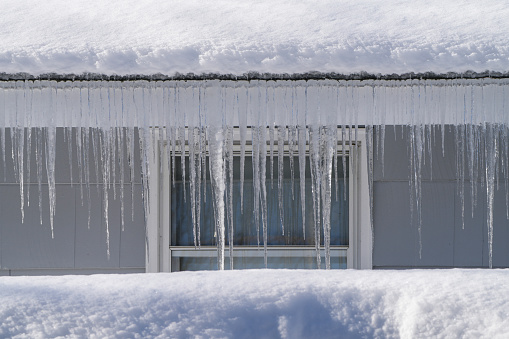 winter house with icicle and snow on the roof