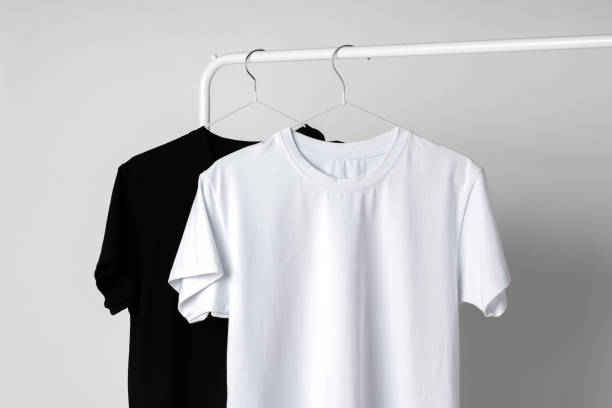 istock Black and white T-shirts hanging against white background studio shot 1971932187