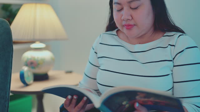 Asian plus size woman reading magazine