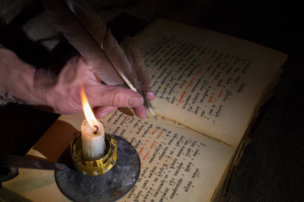 istock old book and hand with a feather 1971946752