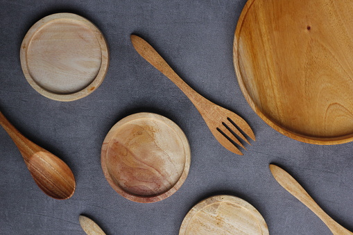 a pile of wooden roaster with fork and spoon. handmade. isolated background