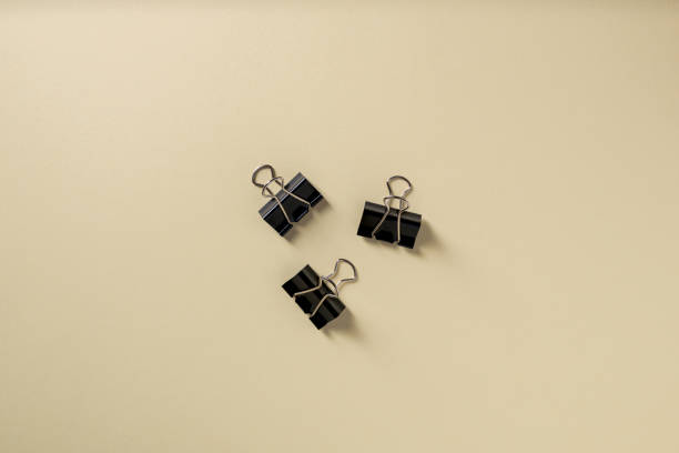 istock Black binder paper clip on yellow background 1971998529
