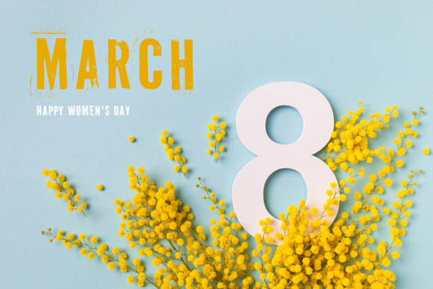 International Women Day on 8 March celebration with fresh spring mimosa flowers and number eight top view. Beautiful holiday greeting background. stock photo