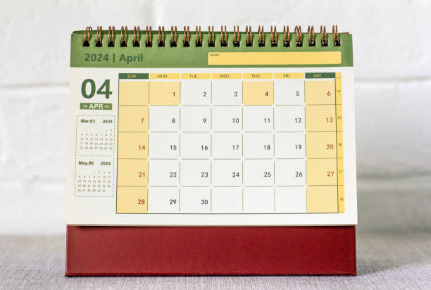 istock Desk calendar for April 2024 and a clock on the table. 1972029323